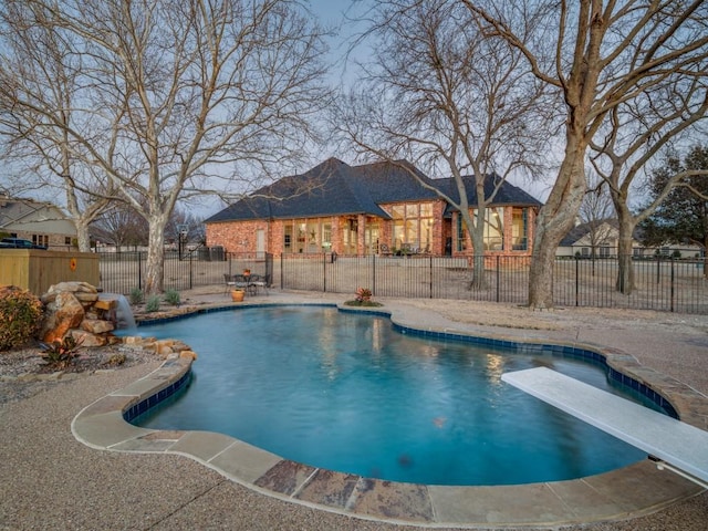 view of pool featuring a diving board, a patio, fence, and a fenced in pool