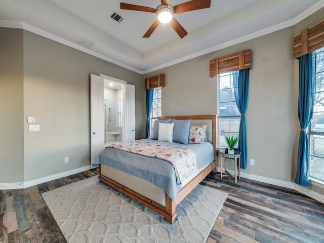 bedroom featuring a tray ceiling, visible vents, baseboards, and multiple windows