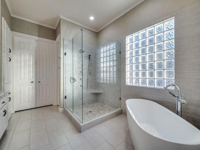 bathroom with ornamental molding, tile walls, a freestanding bath, and a shower stall