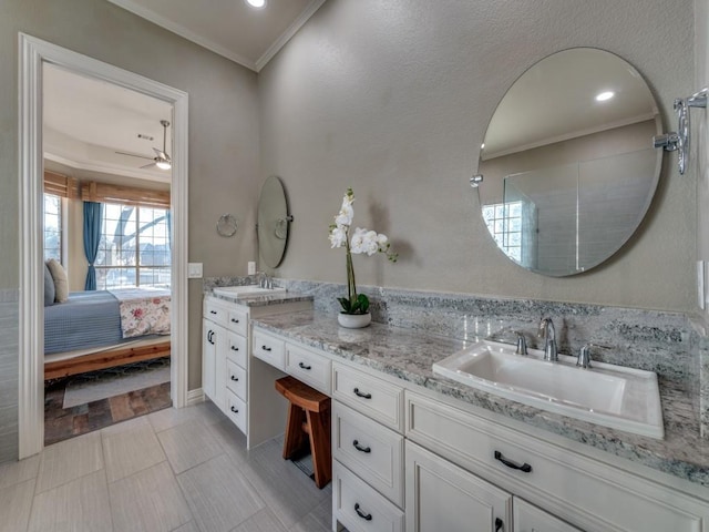 bathroom with double vanity, crown molding, connected bathroom, and a sink