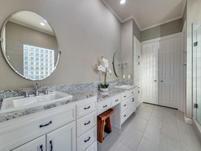 full bathroom with double vanity, a shower stall, crown molding, and a sink