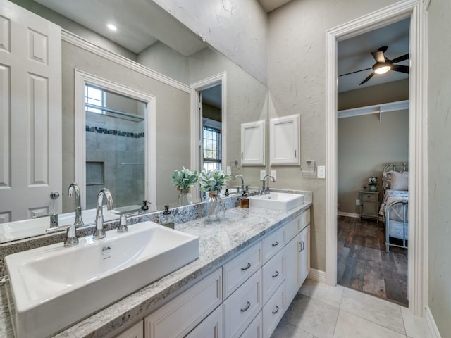 full bathroom featuring tile patterned flooring, a sink, baseboards, and double vanity