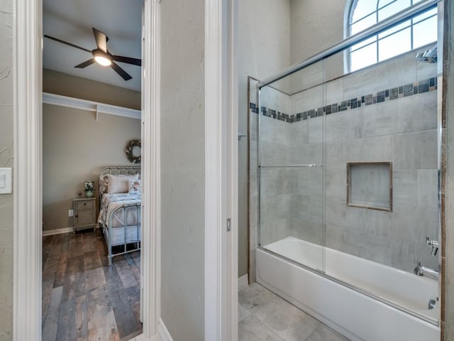 full bathroom with enclosed tub / shower combo, baseboards, a ceiling fan, and wood finished floors