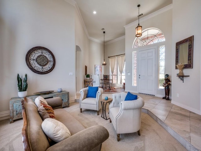 foyer with arched walkways, light tile patterned flooring, a towering ceiling, baseboards, and crown molding