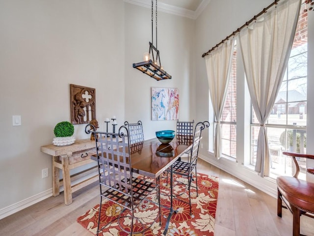 dining area with a notable chandelier, baseboards, ornamental molding, and wood finished floors