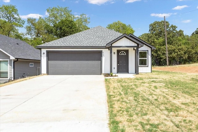 view of front of property with an attached garage, a shingled roof, driveway, board and batten siding, and a front yard