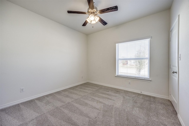 spare room with carpet, baseboards, and a ceiling fan