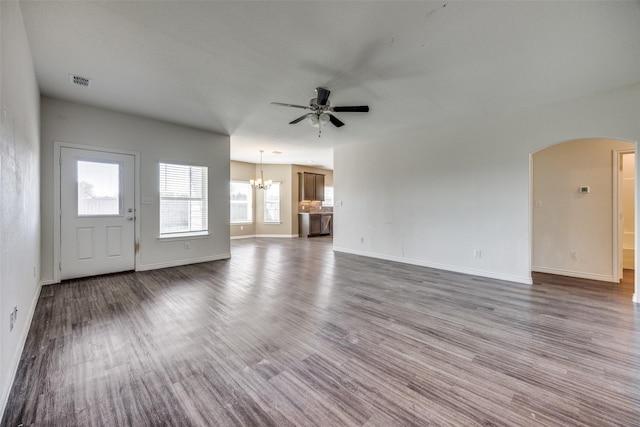 unfurnished living room with baseboards, visible vents, arched walkways, wood finished floors, and ceiling fan with notable chandelier