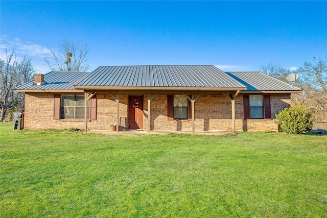 ranch-style house with brick siding, a chimney, metal roof, and a front yard