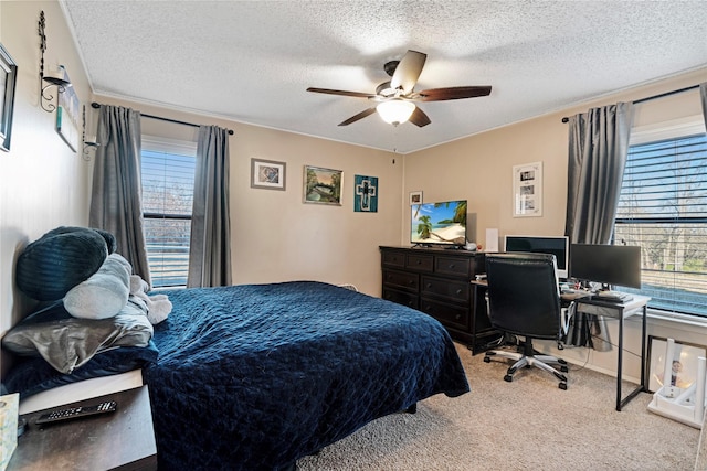 carpeted bedroom featuring a textured ceiling, multiple windows, and a ceiling fan