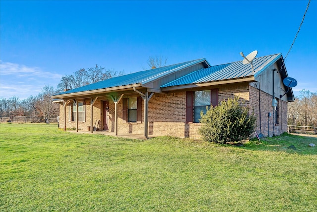 ranch-style home with metal roof, brick siding, and a front lawn