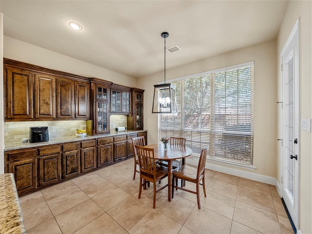 dining space with light tile patterned floors, visible vents, and baseboards