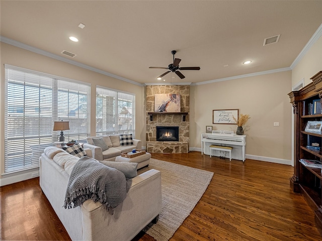 living room with a fireplace, visible vents, wood finished floors, and ornamental molding