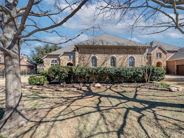 view of front of property with brick siding and a shingled roof