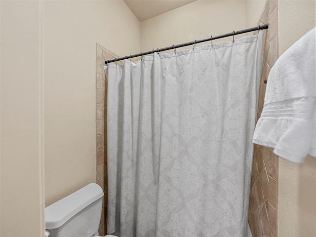 full bathroom featuring toilet and a shower with shower curtain