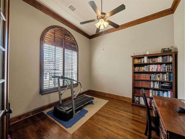 exercise area featuring dark wood-style floors, baseboards, visible vents, and ornamental molding