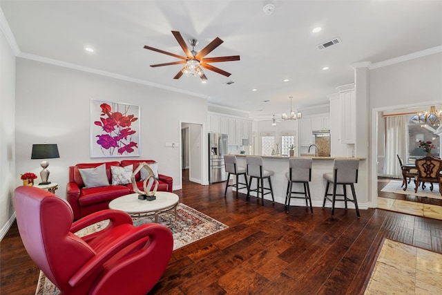 living area with dark wood finished floors, visible vents, and crown molding