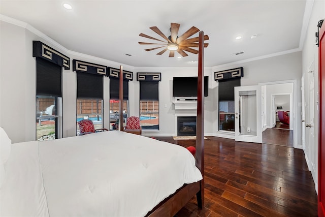 bedroom with a glass covered fireplace, hardwood / wood-style flooring, visible vents, and ornamental molding