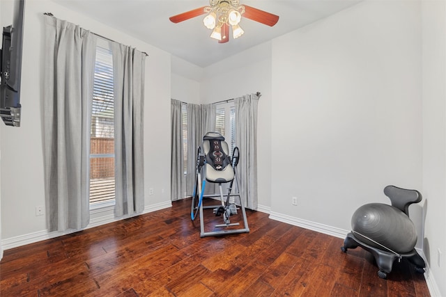 exercise room featuring a wealth of natural light, baseboards, ceiling fan, and hardwood / wood-style flooring