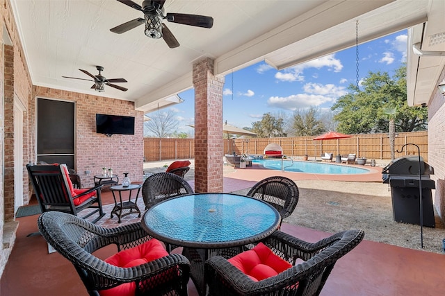 view of patio featuring a fenced in pool, a fenced backyard, ceiling fan, grilling area, and outdoor dining area