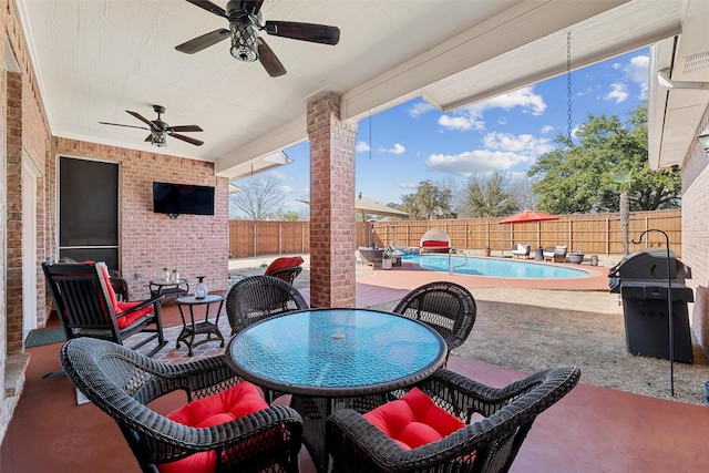 view of patio / terrace featuring outdoor dining space, a ceiling fan, a fenced in pool, a fenced backyard, and a grill