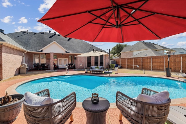 view of pool featuring a patio, fence, a fenced in pool, and french doors