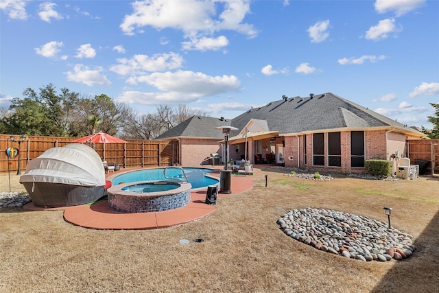 view of pool featuring a patio area, a fenced backyard, and a pool with connected hot tub