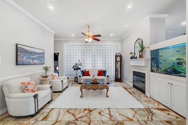 living room with baseboards, a ceiling fan, a glass covered fireplace, crown molding, and recessed lighting