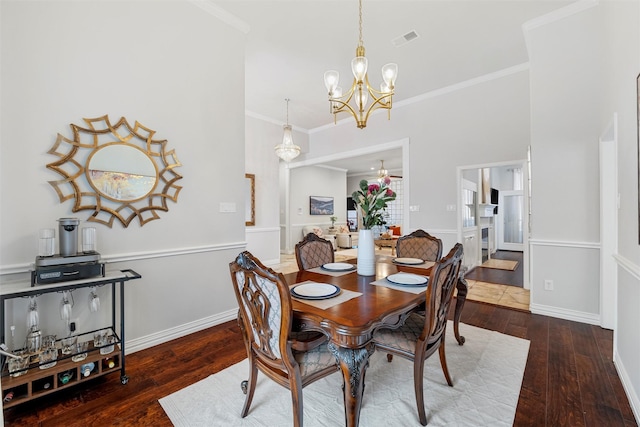 dining area with a notable chandelier, crown molding, visible vents, and wood-type flooring