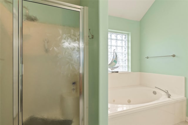 bathroom featuring a shower stall and a tub with jets