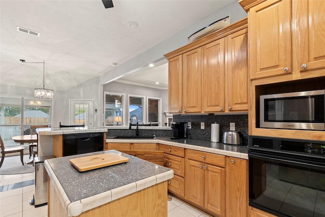 kitchen featuring light tile patterned floors, visible vents, a kitchen island, black appliances, and a sink