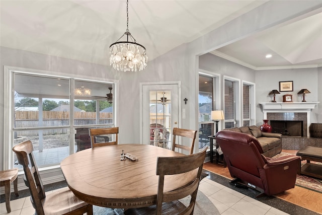 dining area with recessed lighting, light tile patterned flooring, ornamental molding, and a tile fireplace