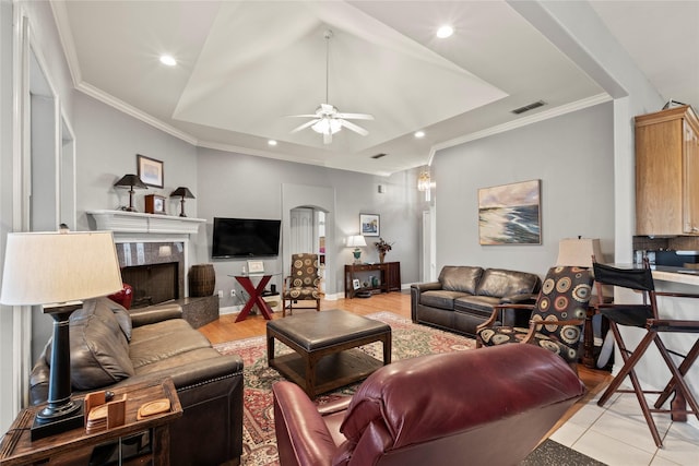 living room featuring ornamental molding, recessed lighting, visible vents, and a tiled fireplace