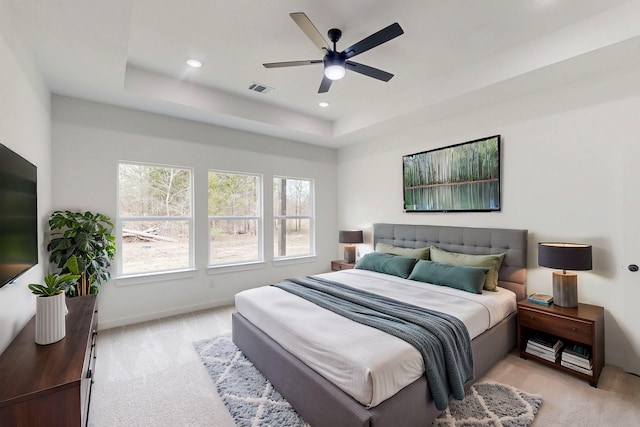 bedroom with recessed lighting, light colored carpet, visible vents, baseboards, and a raised ceiling