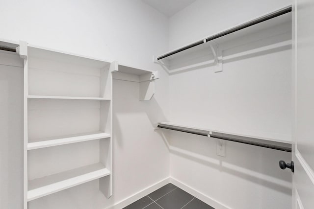 spacious closet featuring dark tile patterned floors