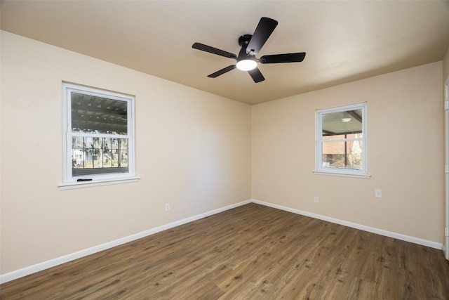 empty room with baseboards, dark wood finished floors, and a ceiling fan