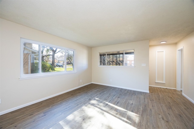 empty room featuring baseboards and wood finished floors