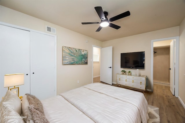 bedroom featuring visible vents, baseboards, wood finished floors, a closet, and a ceiling fan