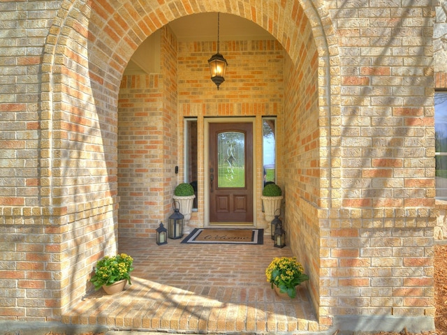 view of exterior entry with brick siding