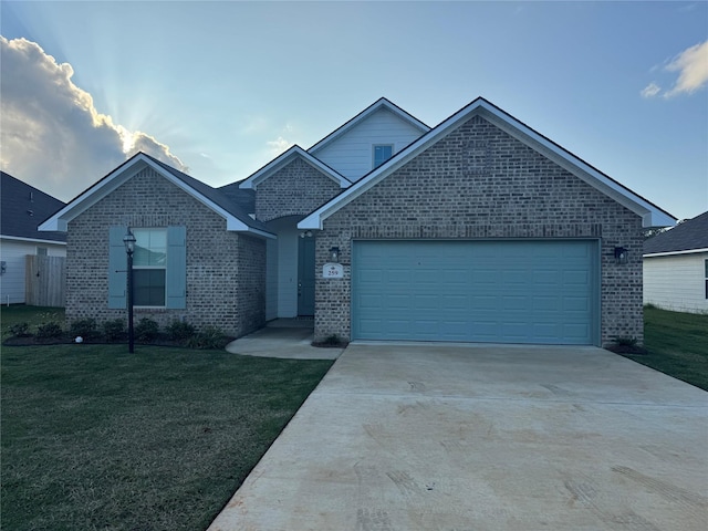 ranch-style home with driveway, an attached garage, a front lawn, and brick siding