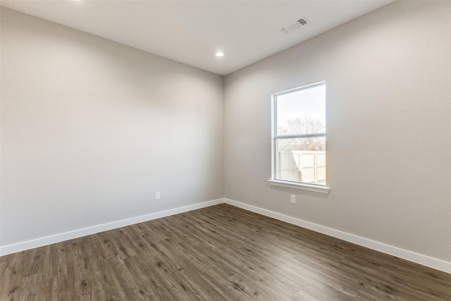 spare room with dark wood-style flooring, recessed lighting, visible vents, and baseboards