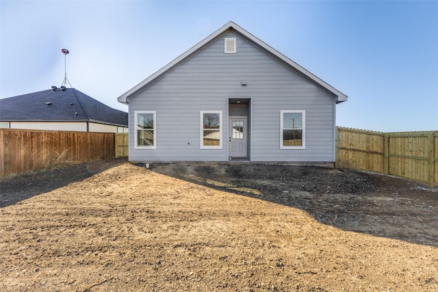 rear view of house featuring a fenced backyard