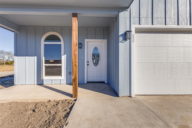 property entrance with board and batten siding and an attached garage