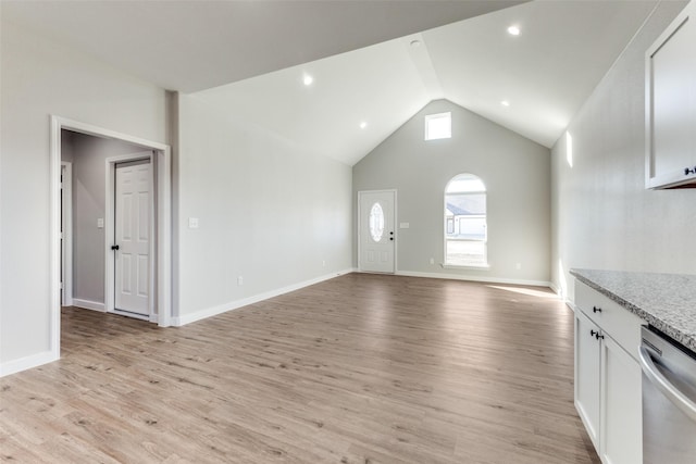 unfurnished living room with high vaulted ceiling, recessed lighting, light wood-style flooring, and baseboards