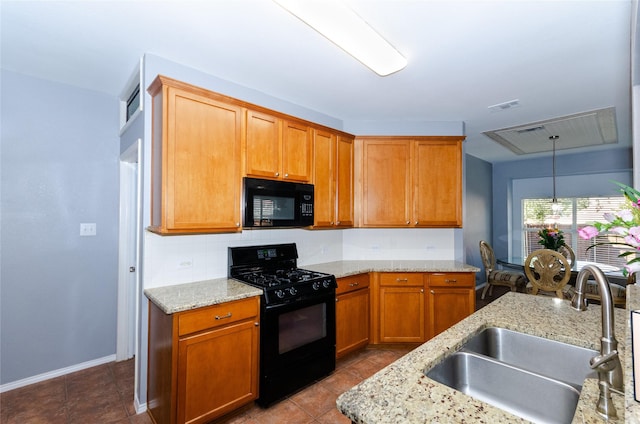 kitchen with visible vents, a sink, light stone countertops, black appliances, and backsplash