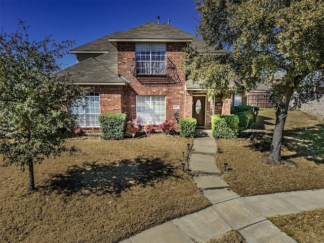 traditional home with brick siding and a shingled roof