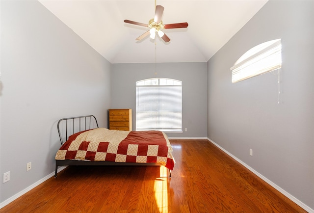 bedroom with ceiling fan, baseboards, vaulted ceiling, and wood finished floors