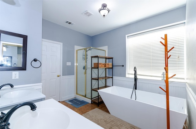 bathroom with a stall shower, visible vents, a soaking tub, and wainscoting