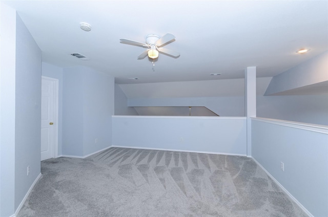 empty room with ceiling fan, carpet floors, visible vents, and baseboards