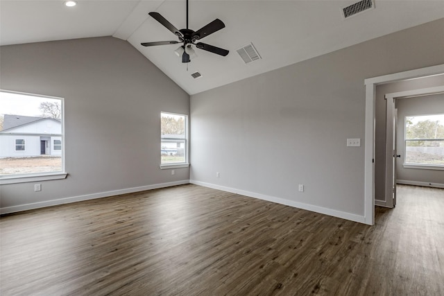 empty room with plenty of natural light, visible vents, and dark wood finished floors